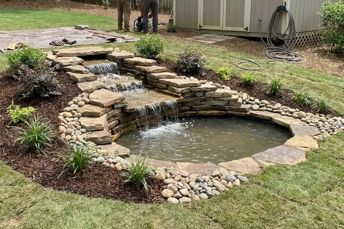 Waterfall flowing over stacked stone into a pond