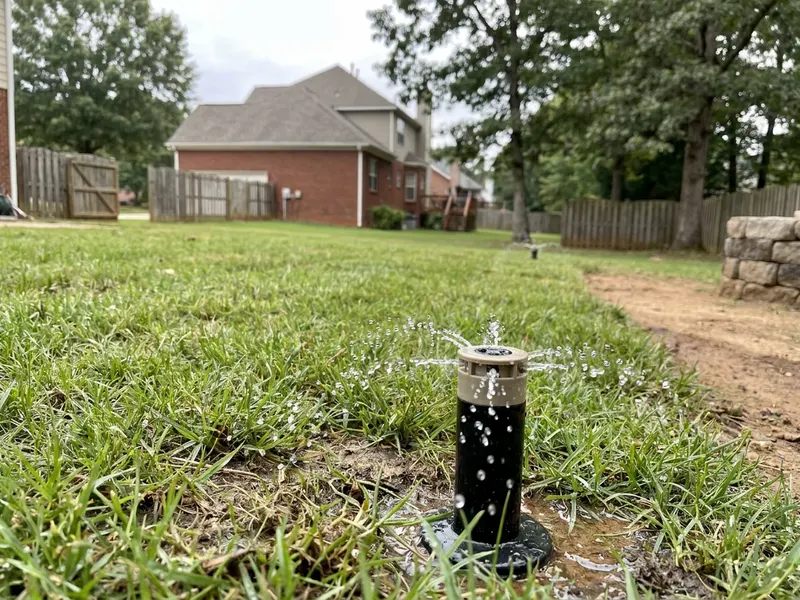 Pop-up sprinkler head watering a lawn